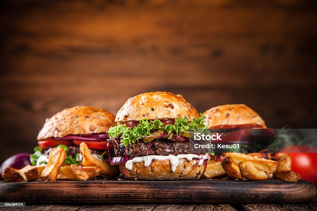 Delicious hamburgers on wooden background
